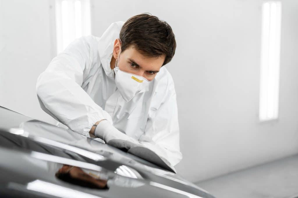 Mann bearbeitet Autoscheibe